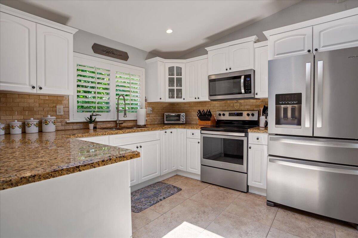 1110 Southwest 15th Street Boca Raton, FL 33486 - Photo 8 of 41 a kitchen with stainless steel appliances granite countertop a stove a sink and a microwave