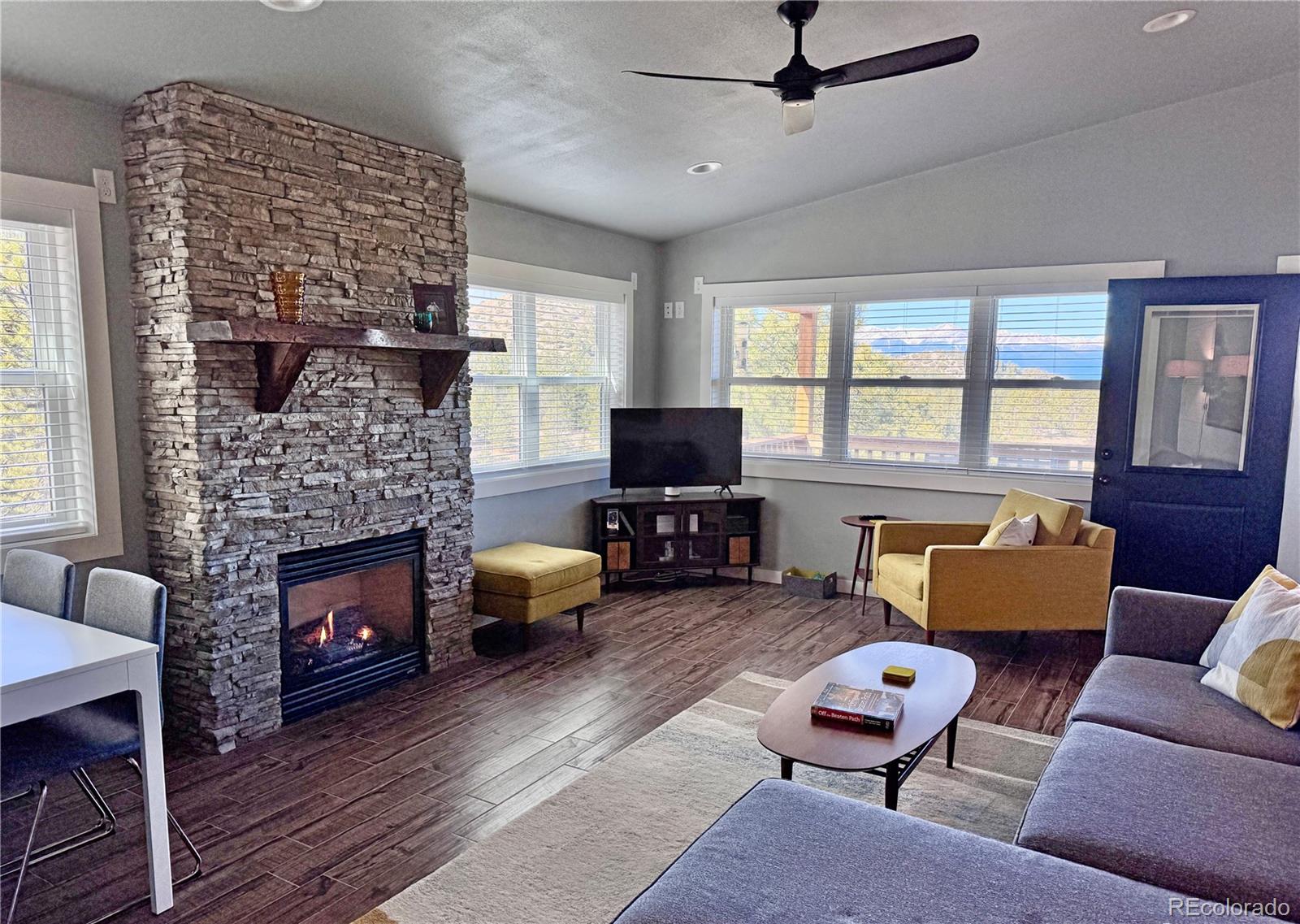 563 Kankakee Road Westcliffe, CO 81252 - Photo 22 of 46 a living room with furniture a fireplace and a flat screen tv
