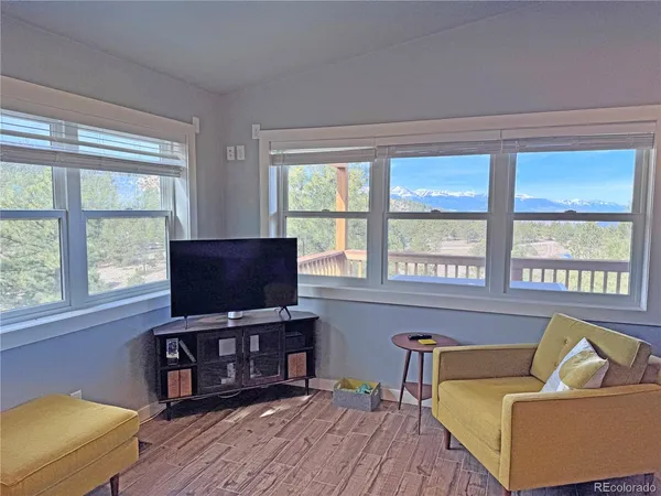 a living room with furniture and a flat screen tv with wooden floor