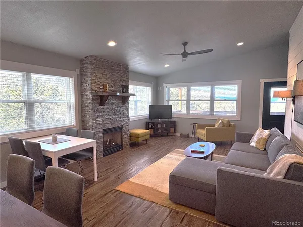 a living room with furniture fireplace and a large window