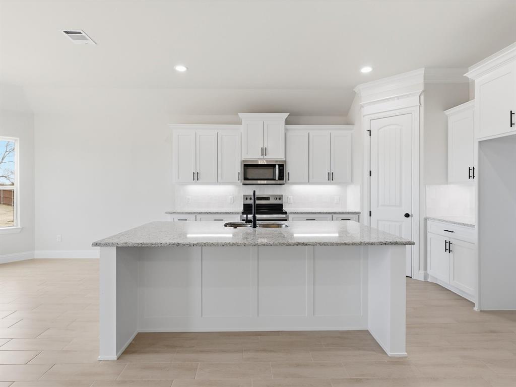 829 Haley Springtown, TX 76082 - Photo 13 of 37 a kitchen with white cabinets and stainless steel appliances