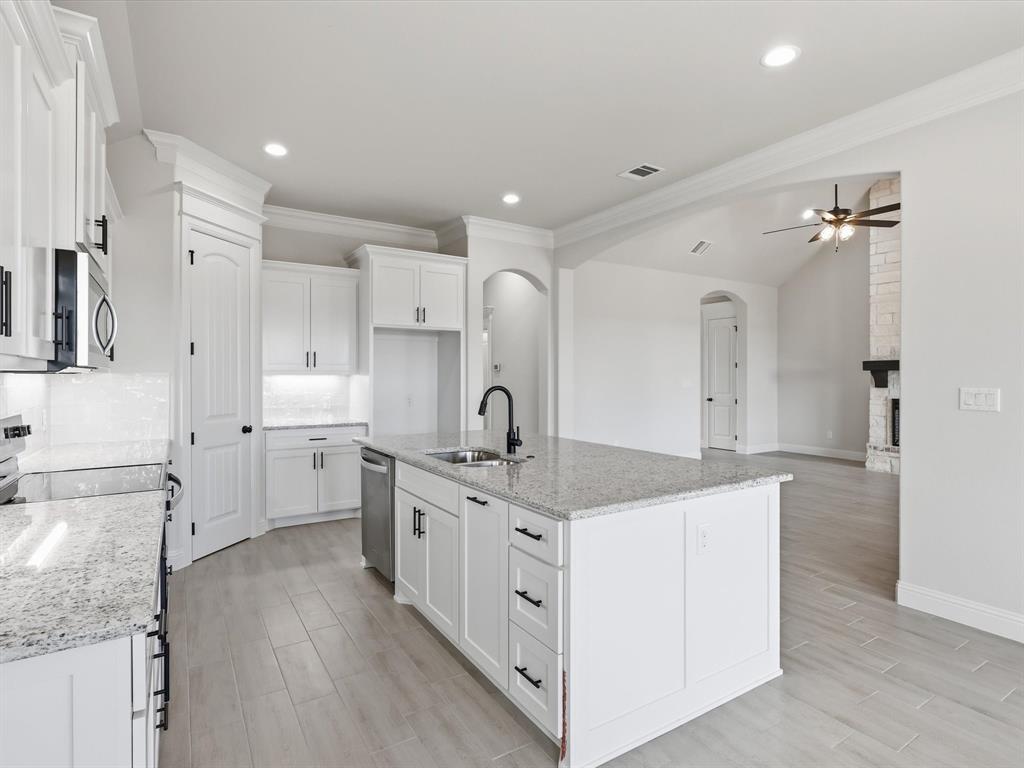 829 Haley Springtown, TX 76082 - Photo 17 of 37 a large white kitchen with stainless steel appliances granite countertop a stove oven a sink dishwasher and white cabinets with wooden floor
