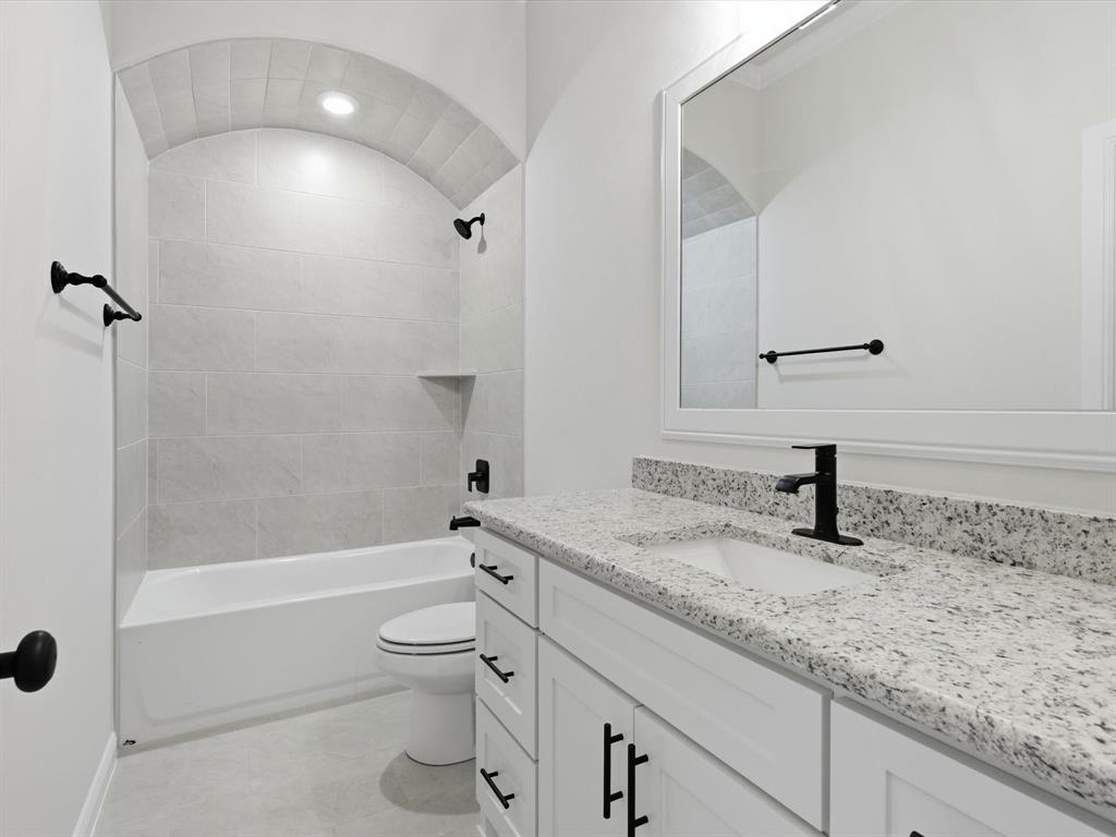 829 Haley Springtown, TX 76082 - Photo 21 of 37 a bathroom with a granite countertop toilet a sink and a bathtub