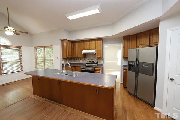 a kitchen with stainless steel appliances granite countertop a refrigerator a sink a stove a microwave and wooden floors