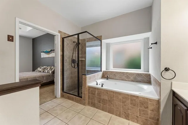 a spacious bathroom with a tub shower and sink