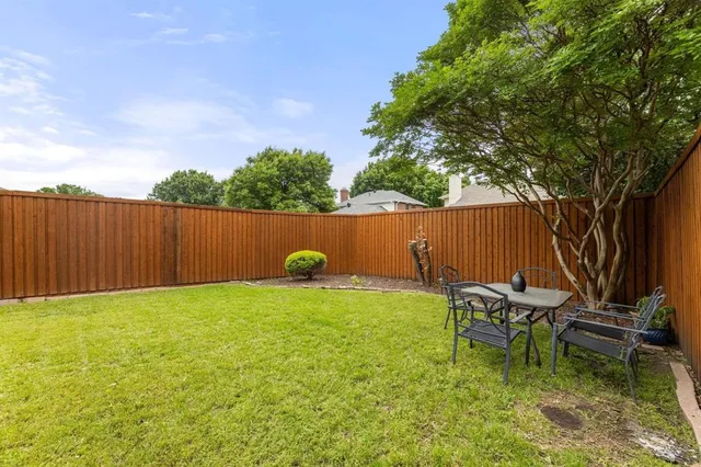 a backyard of a house with table and chairs
