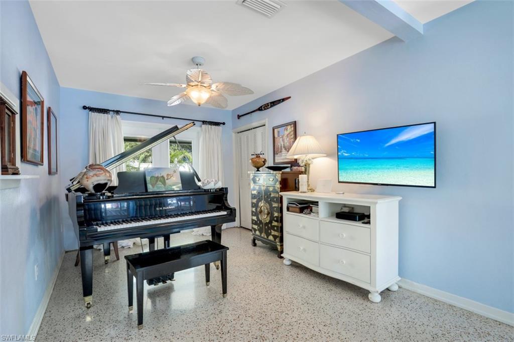 409 3rd Avenue North Naples, FL 34102 - Photo 16 of 41 a living room with furniture a piano and a flat screen tv
