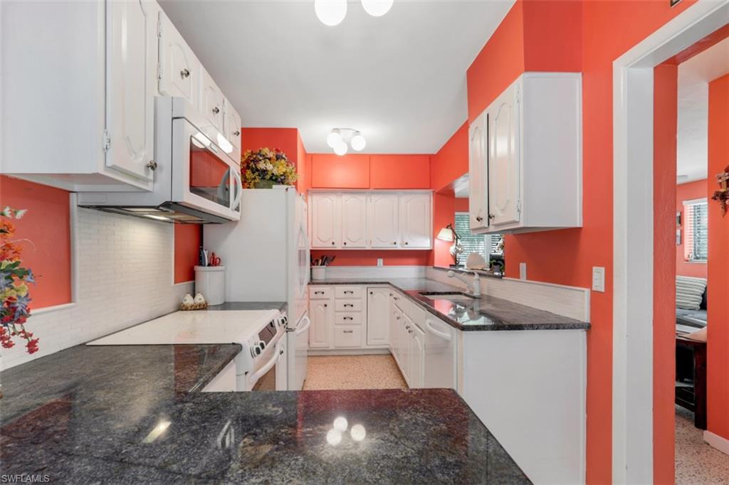 409 3rd Avenue North Naples, FL 34102 - Photo 18 of 41 a kitchen with stainless steel appliances granite countertop a sink stove and cabinets