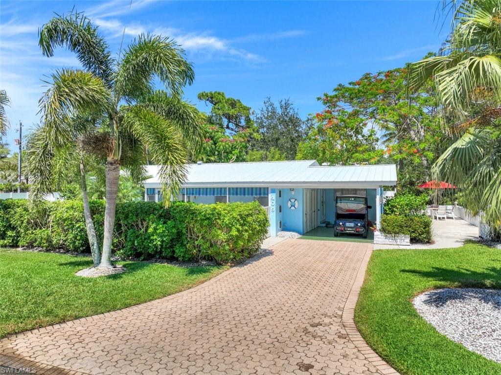 409 3rd Avenue North Naples, FL 34102 - Photo 10 of 41 a front view of a house with a garden and a tree