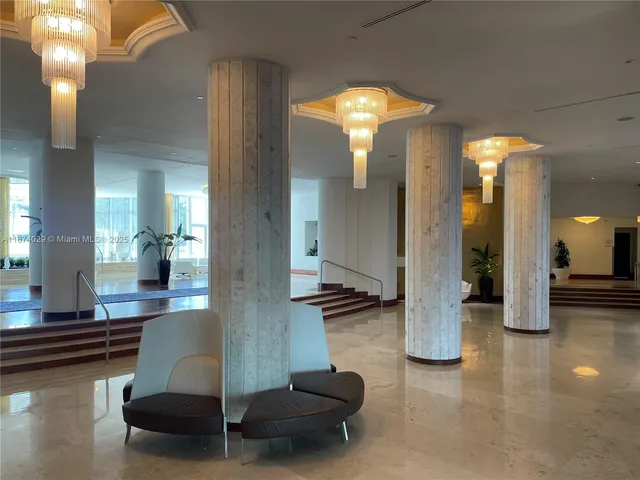 a lobby with furniture and a chandelier