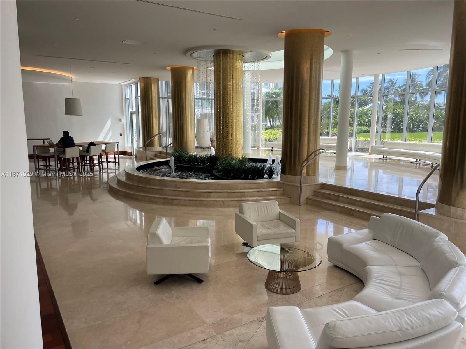 5151 Collins Avenue, Unit 1525 Miami Beach, FL 33140 - Photo 14 of 17 a living room with furniture and large windows