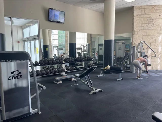 a living room with furniture a window and gym equipment