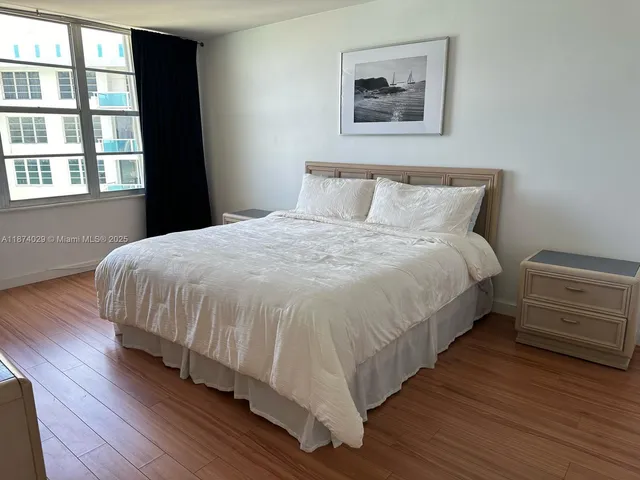 a large bed sitting in a bedroom next to a window