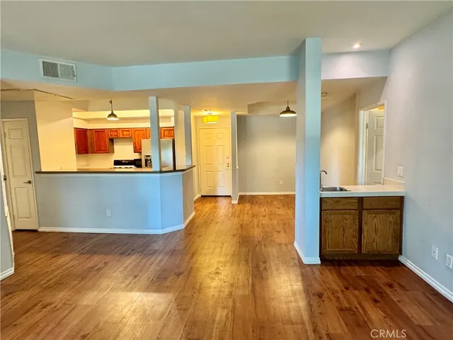 a view of a kitchen with wooden floor and a sink