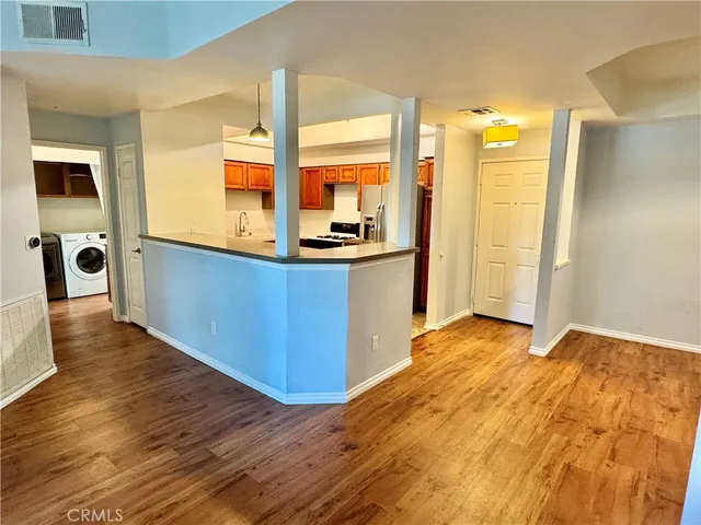 a view of a kitchen with a sink and dishwasher a refrigerator with wooden floor