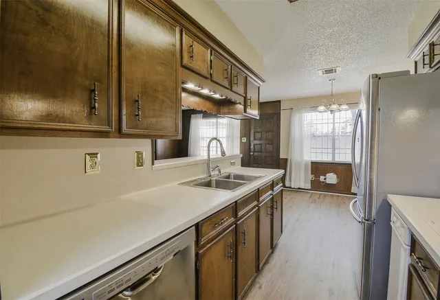 a kitchen with stainless steel appliances a sink and a refrigerator