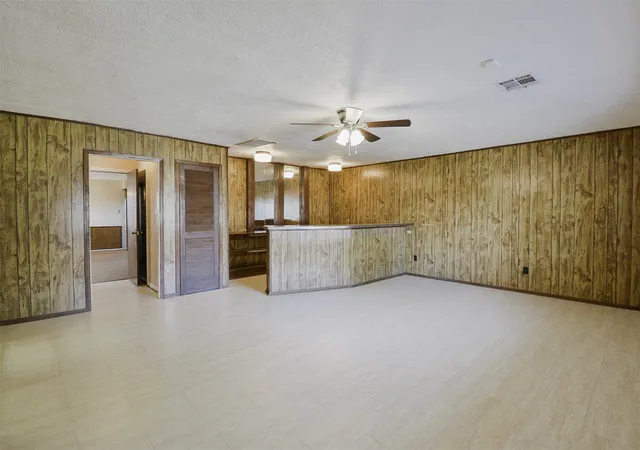 an empty room with a cabinet and mirrors