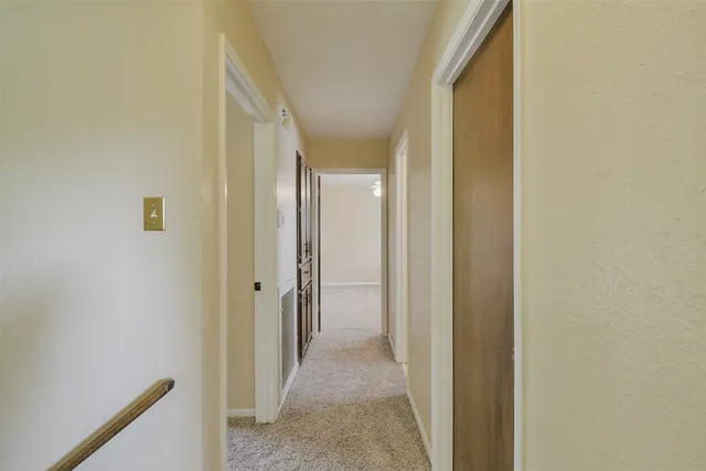 a view of a hallway with wooden shelves