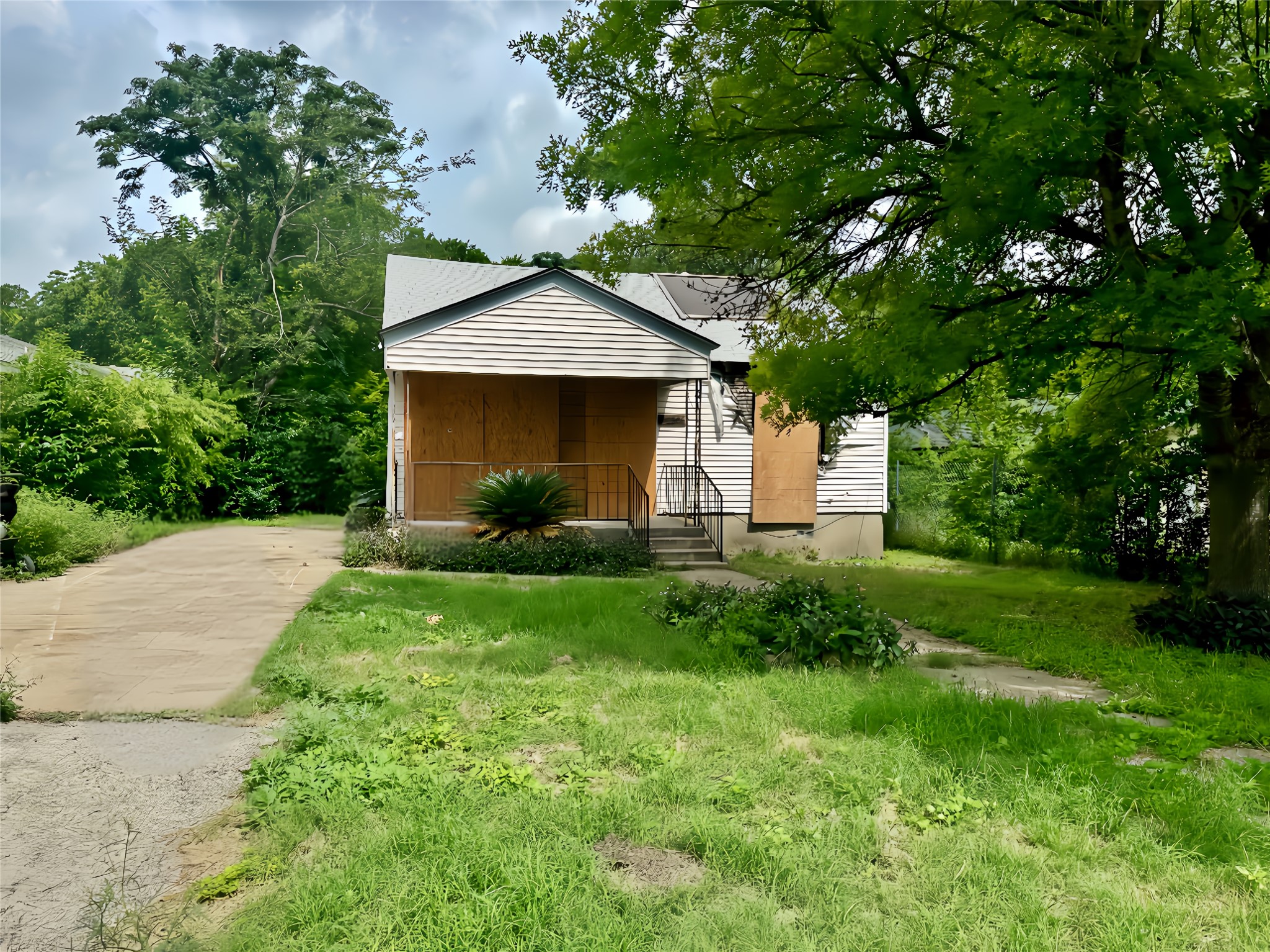 A promising project house with abundant greenery and a concrete driveway awaits its next chapter.