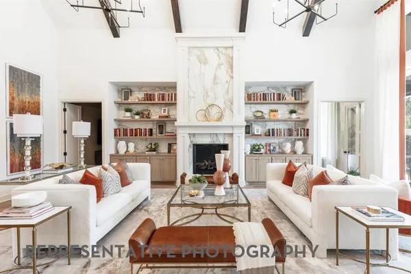a living room with furniture a rug a fireplace and a large window
