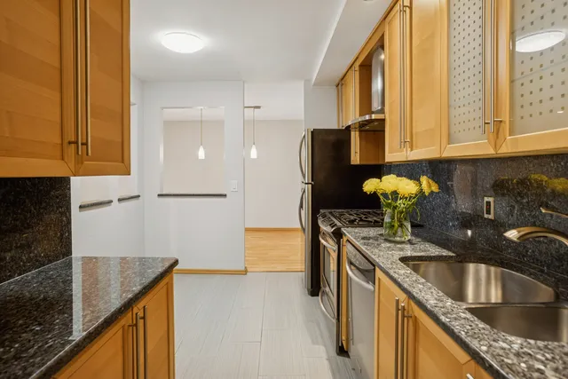a kitchen with granite countertop a sink a stove and refrigerator