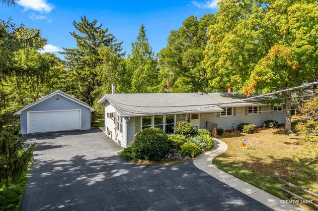 a view of a house with a yard and large tree
