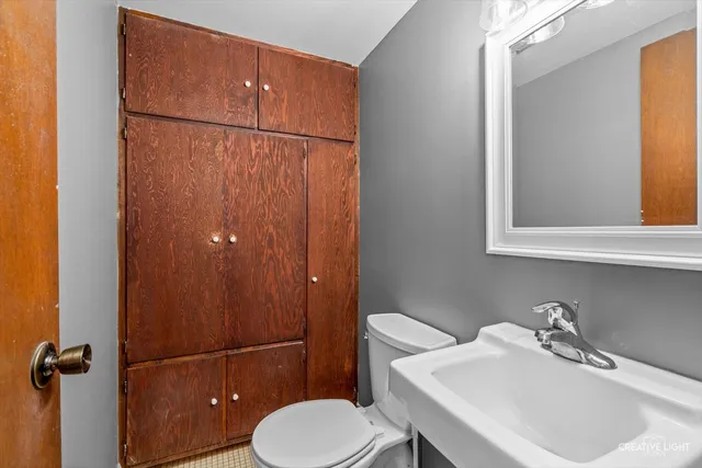 a bathroom with a sink vanity mirror and toilet