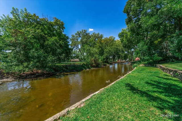 an aerial view of residential house with outdoor space and trees all around
