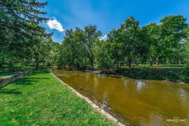 front view of a house with a yard and fountain in middle