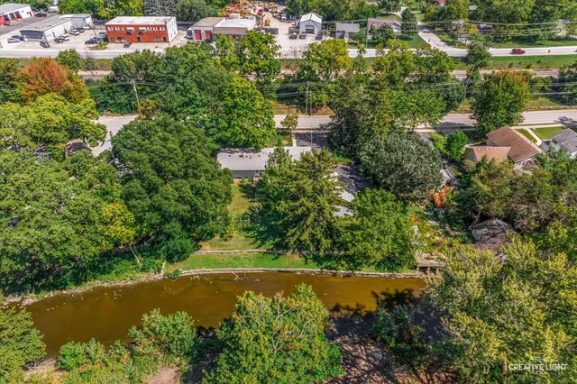 an aerial view of residential houses with outdoor space and lake view