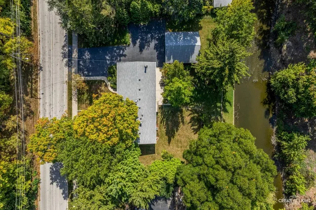 an aerial view of residential houses with outdoor space and trees
