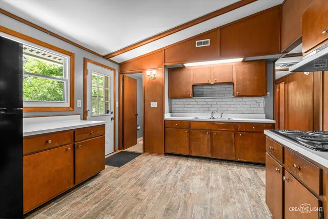 a kitchen with stainless steel appliances granite countertop a stove a sink and a refrigerator