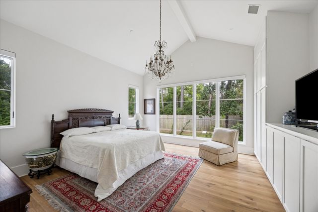 a bedroom with a large bed a flat screen tv and a couch