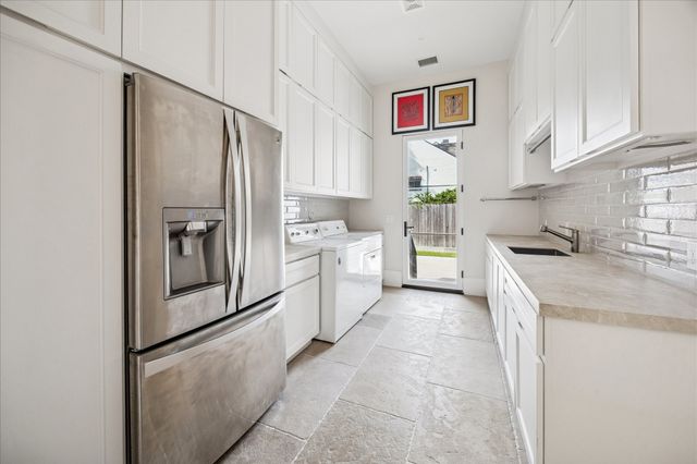 a kitchen with white cabinets and refrigerator