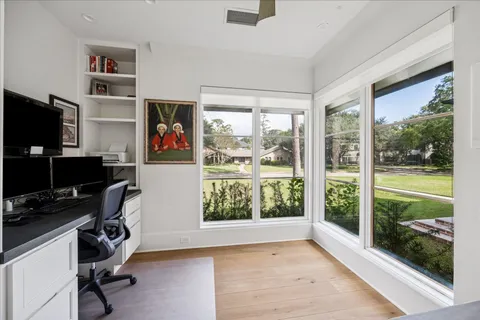 a view of a workspace with furniture and a window