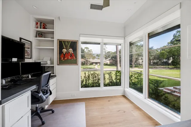 a view of a workspace with furniture and a window