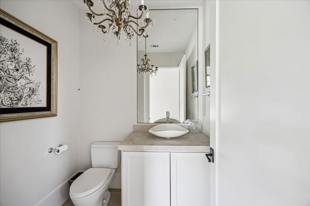a bathroom with a granite countertop sink a toilet and a mirror