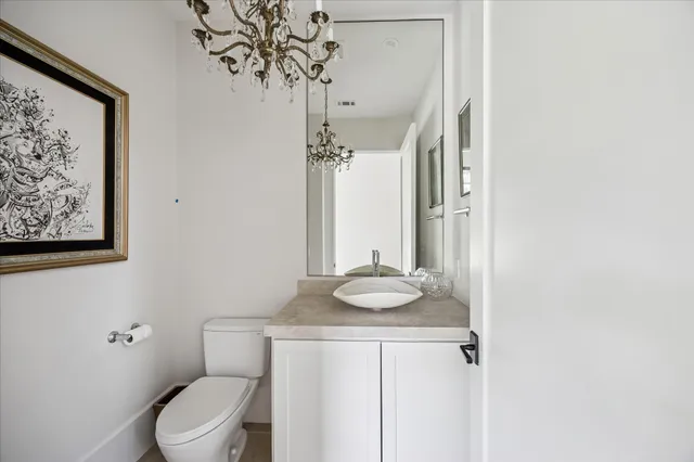 a bathroom with a granite countertop sink a toilet and a mirror