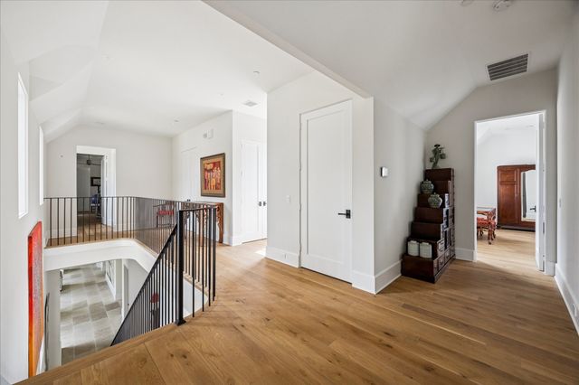a view of a hallway with wooden floor and stairs
