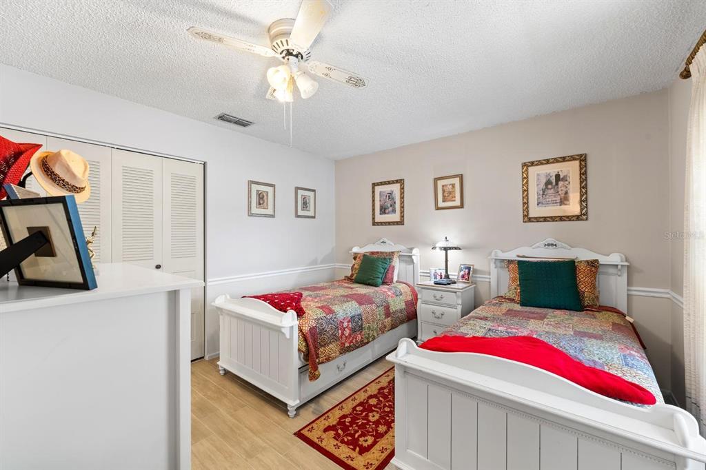 11404 Stansberry Drive Port Richey, FL 34668 - Photo 12 of 30 a bedroom with two beds and a chandelier