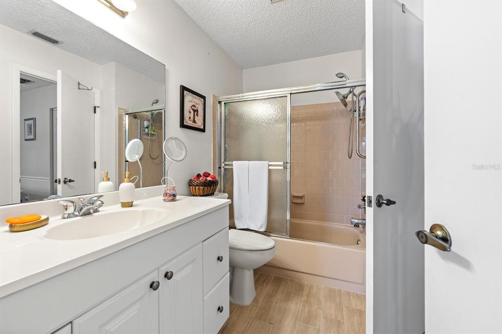 11404 Stansberry Drive Port Richey, FL 34668 - Photo 16 of 30 a bathroom with a double vanity sink toilet mirror and shower