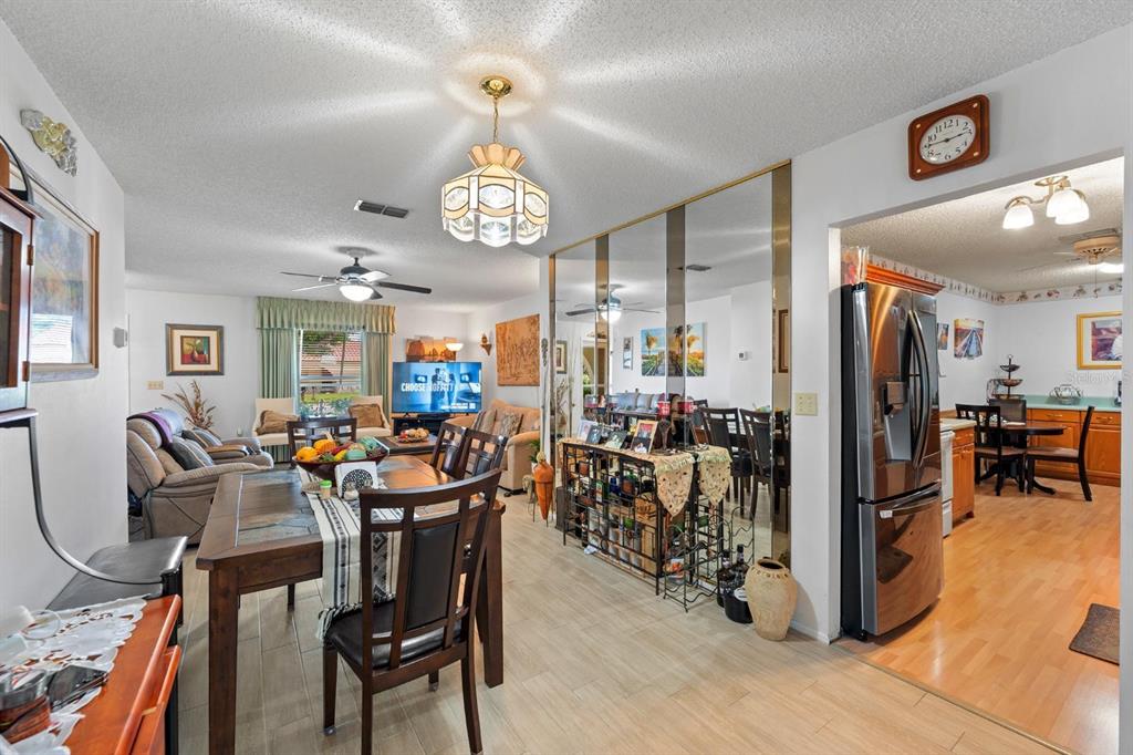 11404 Stansberry Drive Port Richey, FL 34668 - Photo 8 of 30 a view of a dining room and livingroom with furniture wooden floor a rug a painting and a chandelier