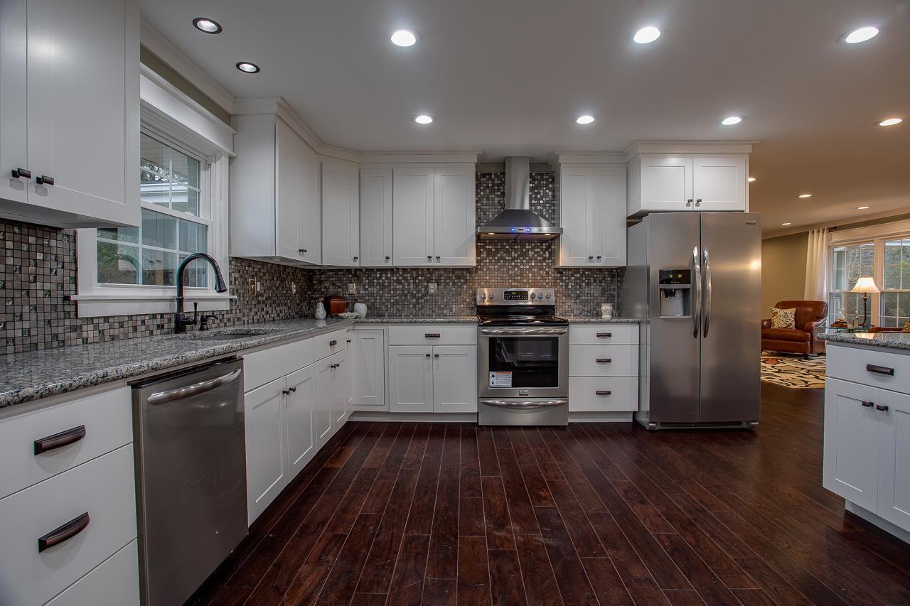 83 You Take It Road Ardmore, TN 38449 - Photo 6 of 30 a kitchen with stainless steel appliances granite countertop a refrigerator a sink dishwasher a stove and white countertops with wooden floor