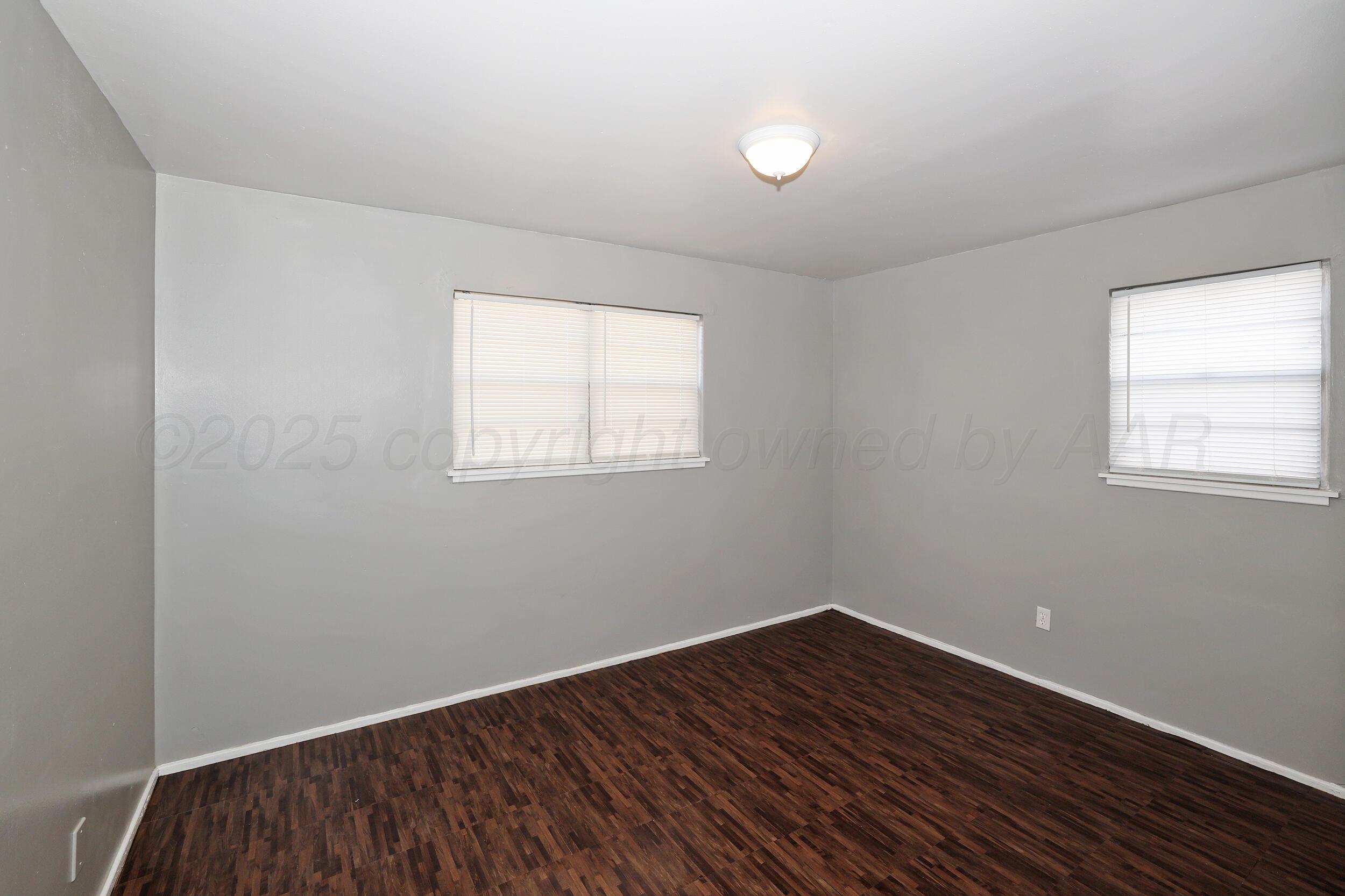 3820 Beaver Drive Amarillo, TX 79107 - Photo 14 of 24 an empty room with wooden floor and windows