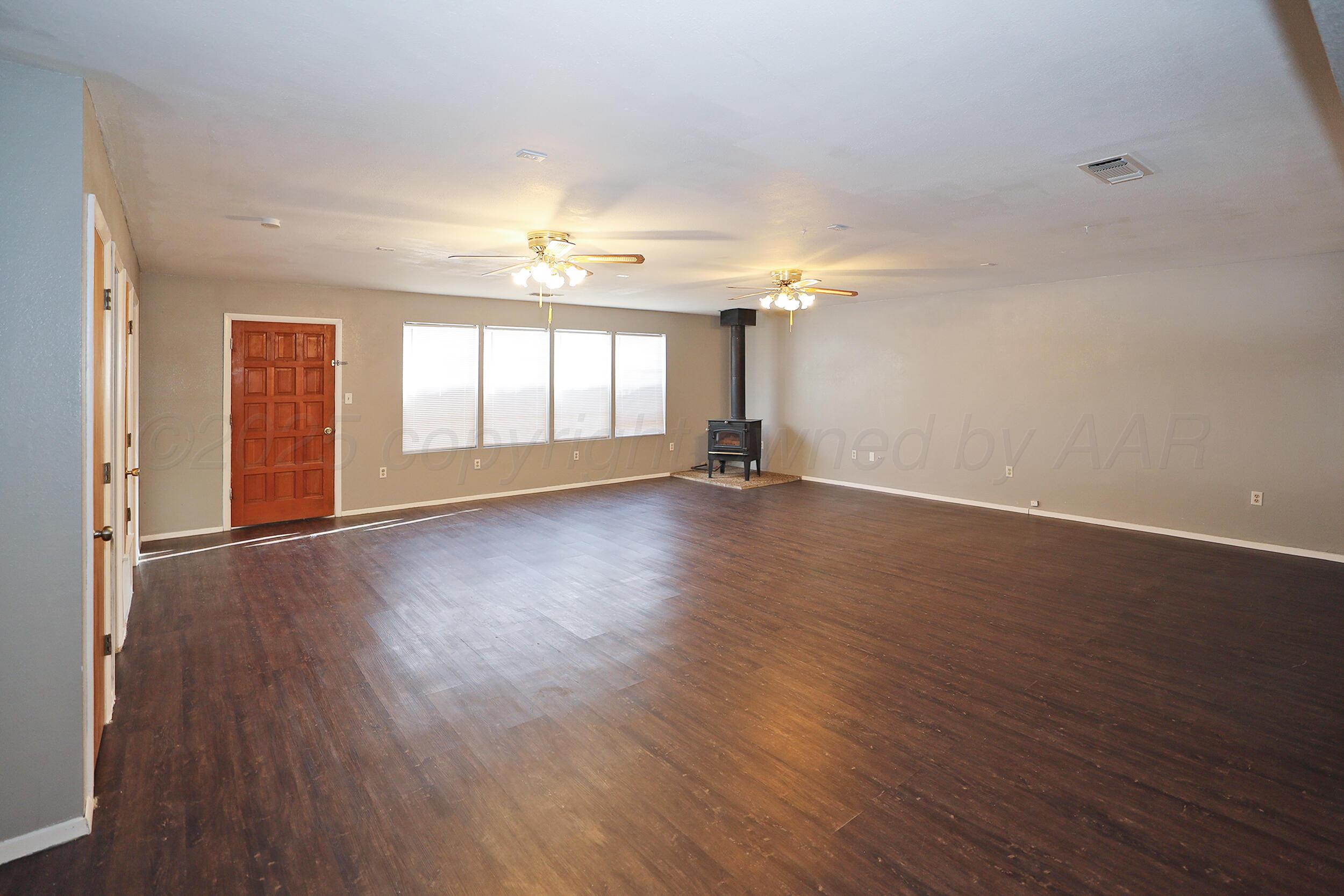 3820 Beaver Drive Amarillo, TX 79107 - Photo 4 of 24 an empty room with wooden floor and windows