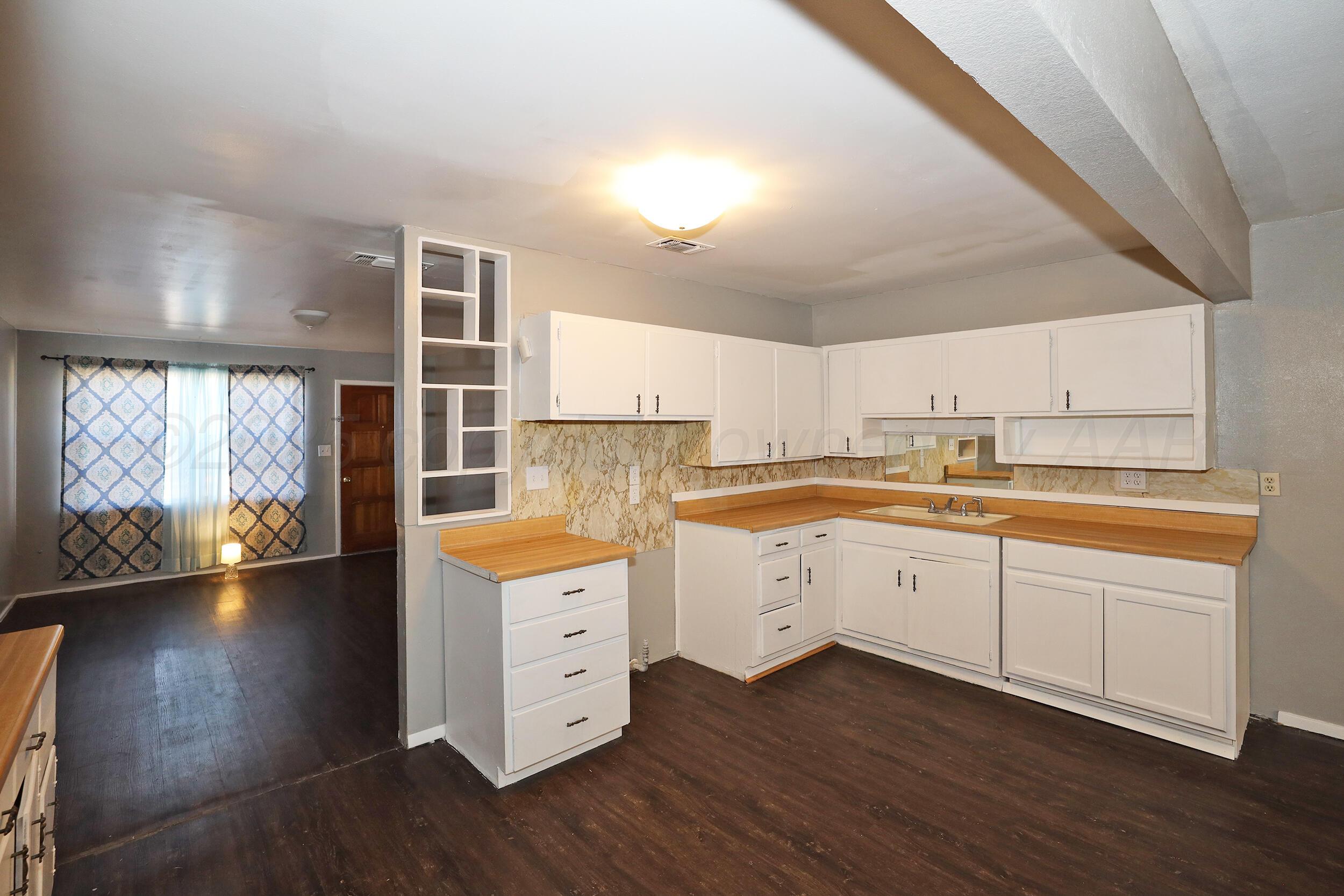 3820 Beaver Drive Amarillo, TX 79107 - Photo 5 of 24 a kitchen with cabinets a sink and wooden floor