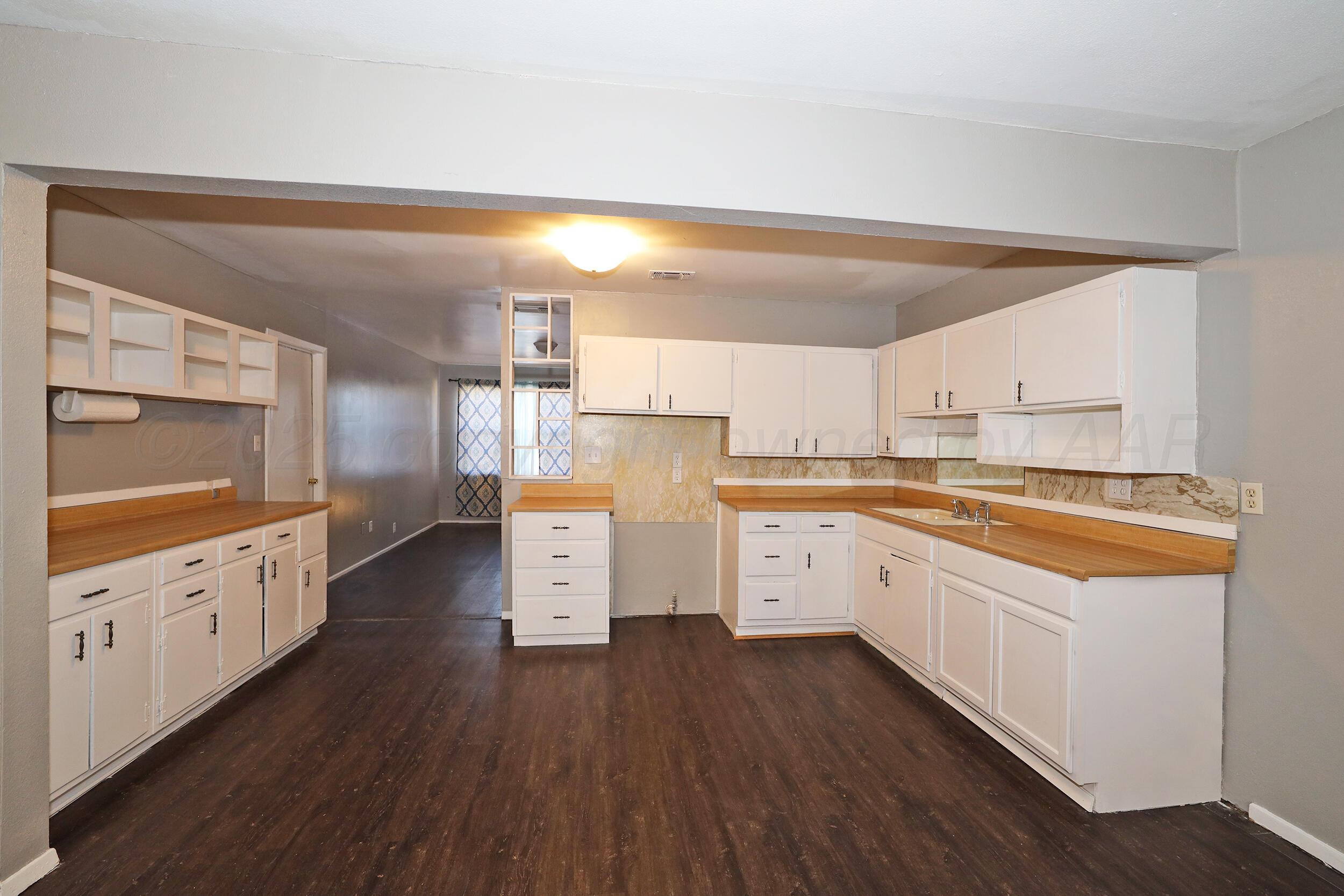 3820 Beaver Drive Amarillo, TX 79107 - Photo 7 of 24 a kitchen with cabinets a sink and wooden floor