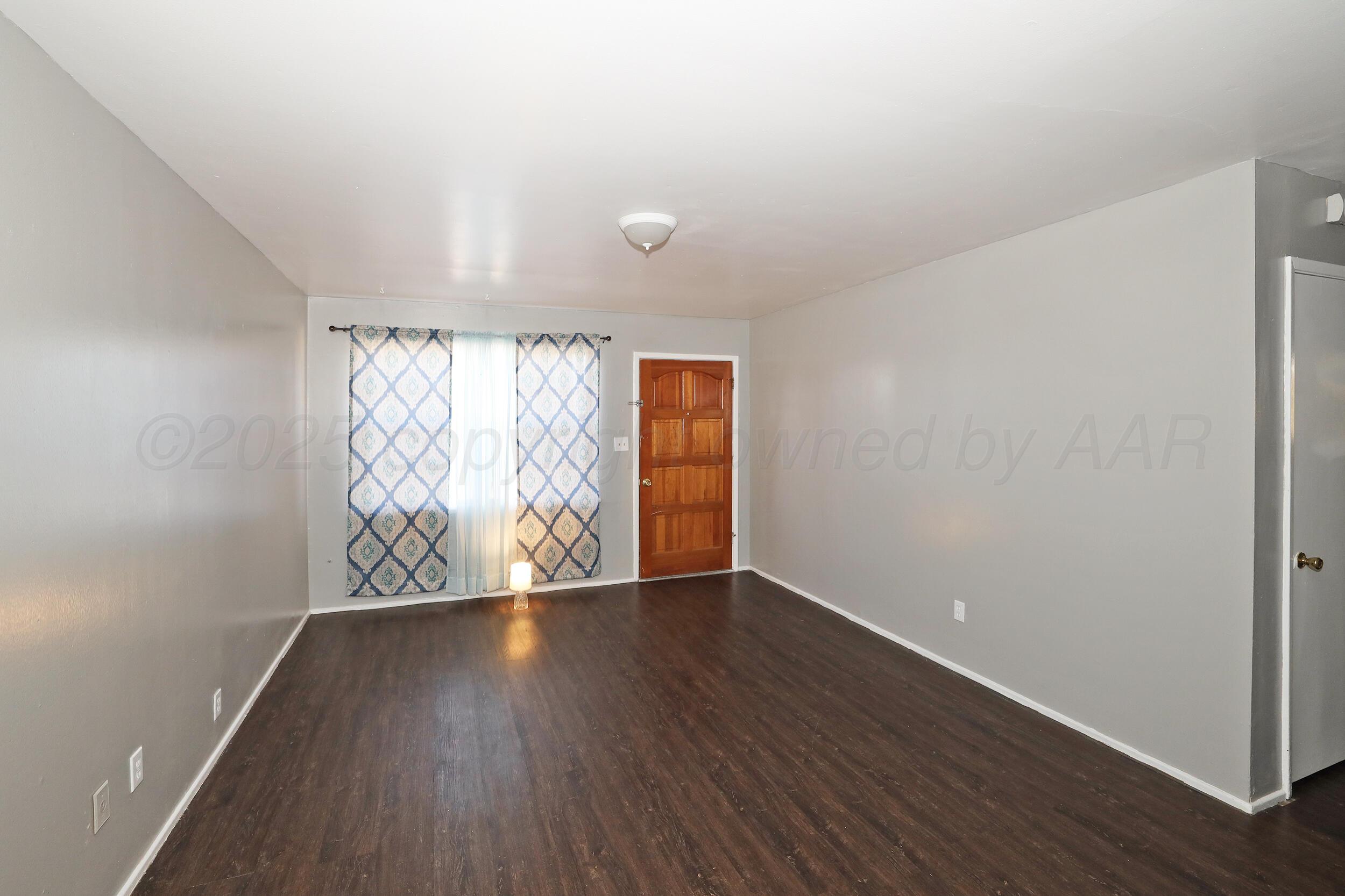 3820 Beaver Drive Amarillo, TX 79107 - Photo 10 of 24 a view of an empty room with wooden floor and a window