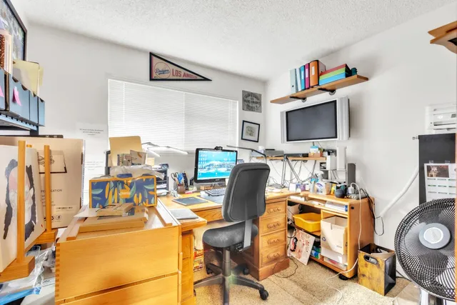 a view of a workspace with furniture and a flat screen tv