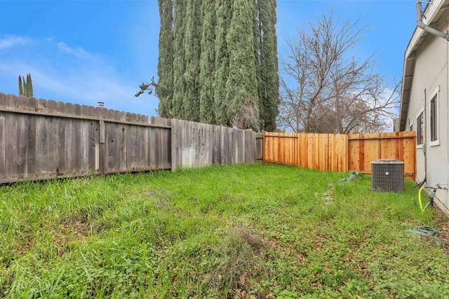 a view of a backyard with wooden fence